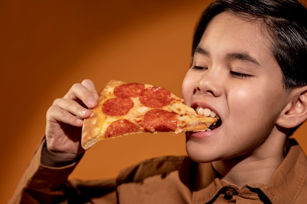 Niño de primer plano comiendo pizza