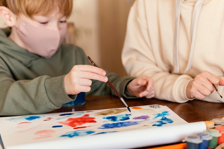 Foto gratuito niño de primer plano con pincel de pintura