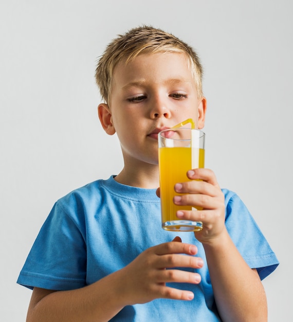 Niño de primer plano con un vaso de jugo