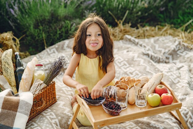 Niño provenzal relajante en campo de lavanda. Niña en un picnic.