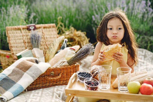 Niño provenzal relajante en campo de lavanda. Niña en un picnic.