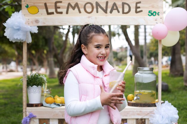 Foto gratuita niño con puesto de limonada