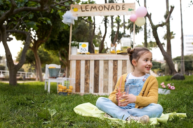 Foto gratuita niño con puesto de limonada