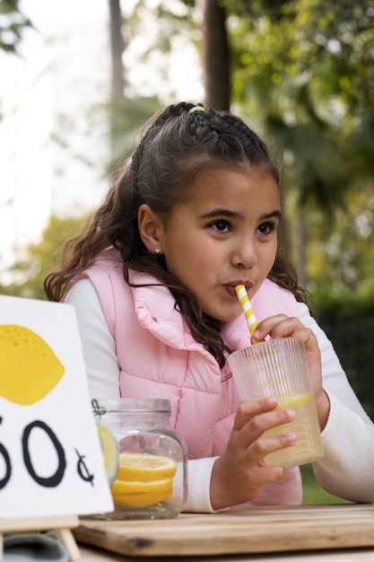 Foto gratuita niño con puesto de limonada