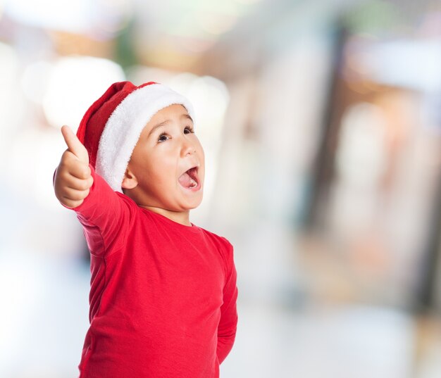 Niño con el pulgar arriba y la boca abierta