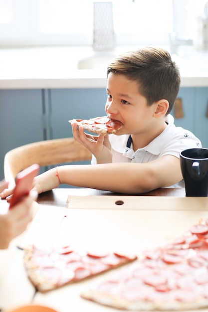 Niño con una rebanada de pizza