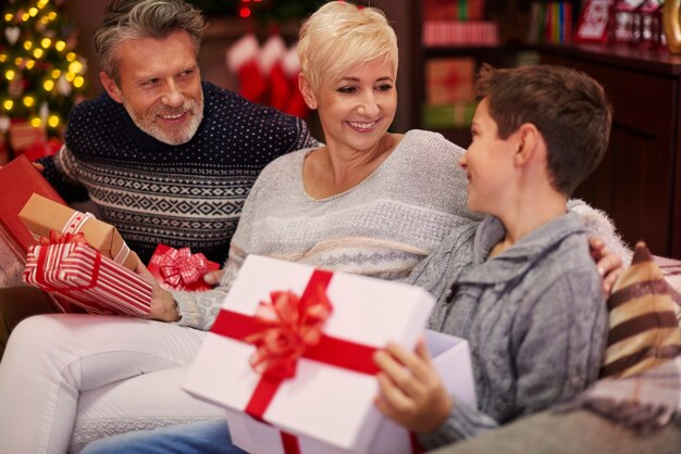 Niño recibiendo un regalo de sus padres