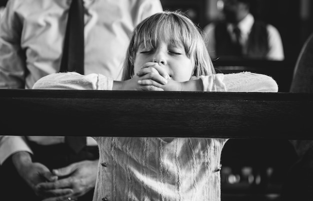 Un niño rezando dentro de la iglesia.