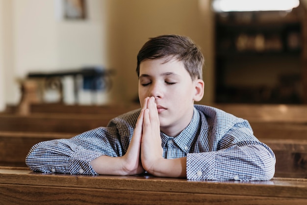 Foto gratuita niño rezando en la iglesia