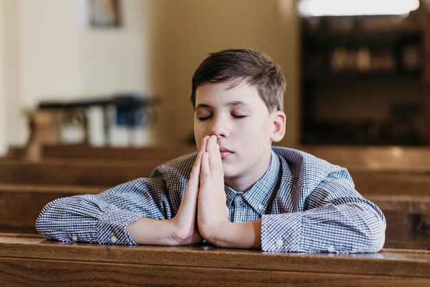 Niño rezando en la iglesia