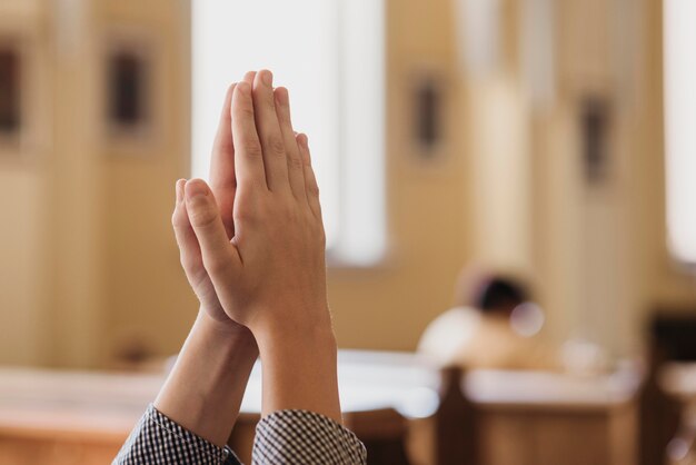 Niño rezando en el primer plano de la iglesia con espacio de copia