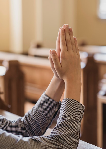 Niño rezando en el primer plano de la iglesia