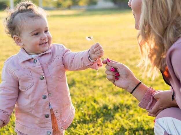 Niño en ropa rosa sosteniendo una flor