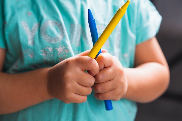 Niño sin rostro con lápices de colores