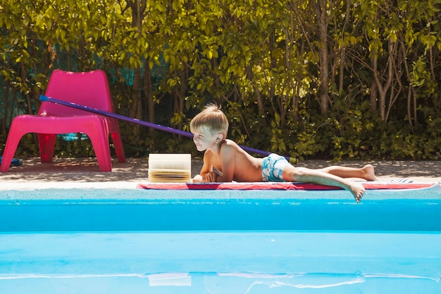 Foto gratuita niño rubio en traje de baño junto a la piscina