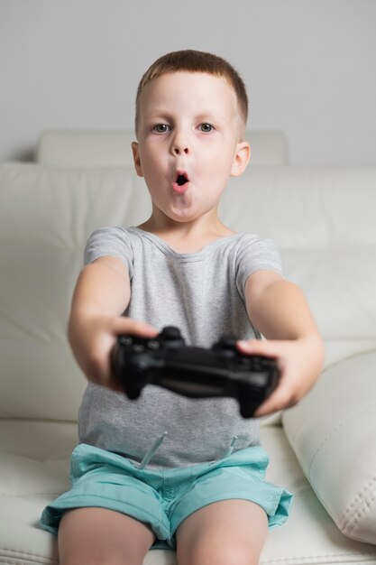 Niño salido en casa jugando con joystick