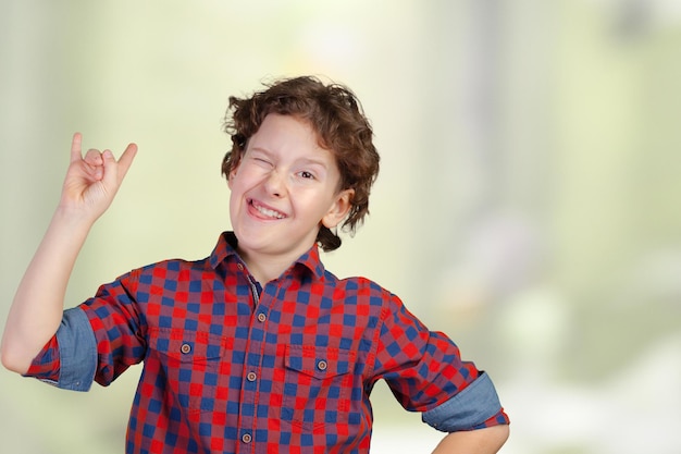 Foto gratuita niño seguro de sí mismo con los puños levantados celebrando un éxito reciente