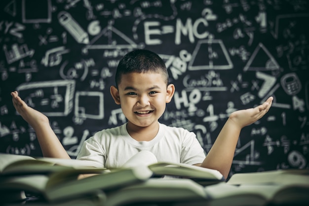 Un niño sentado en el aula leyendo un libro.