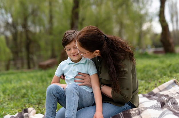 Niño sentado en el parque con su abuela