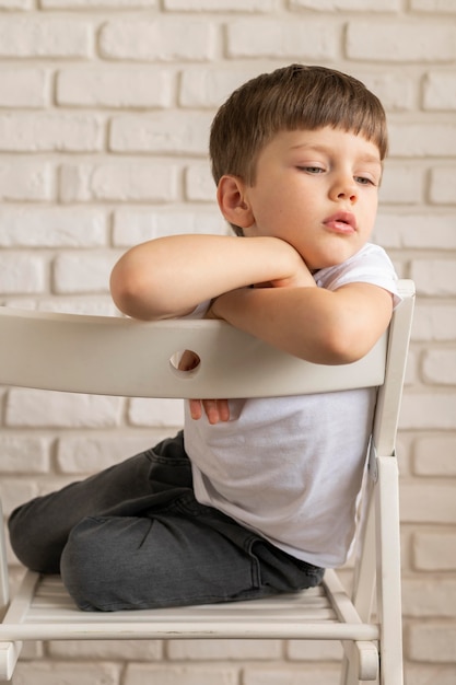 Foto gratuita niño sentado en la silla