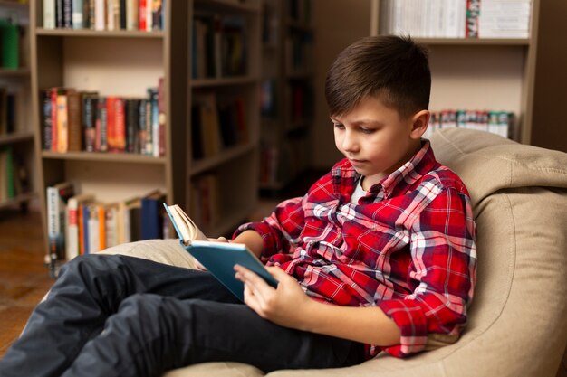 Niño sentado en el sofá y leyendo