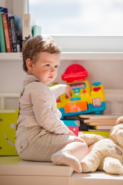 Niño, sentado, ventana, juego, juguetes