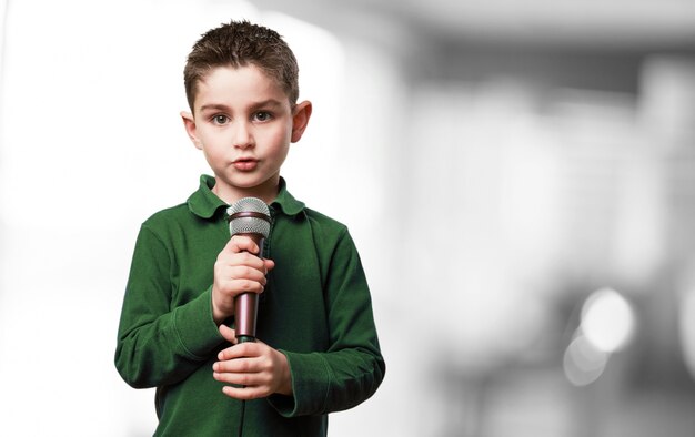 Niño serio con un microfono