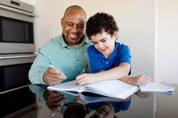 Niño siendo educado en casa por su padre en la nueva normalidad