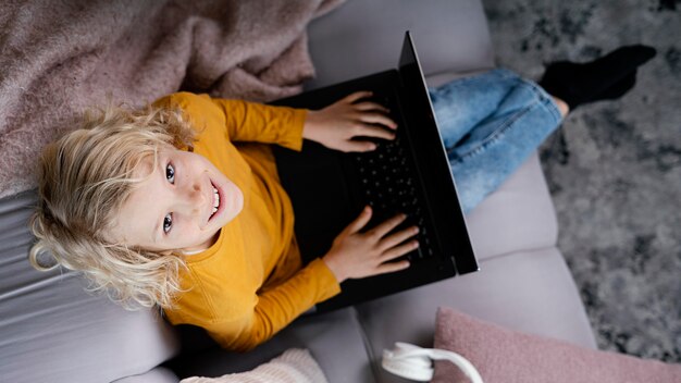 Niño, en, sofá, con, computador portatil