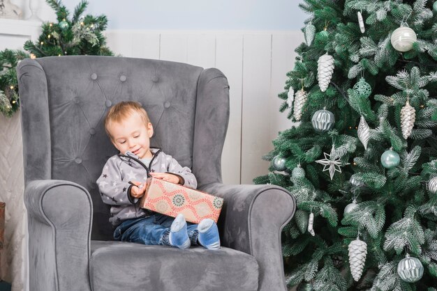 Niño en sofá con regalo