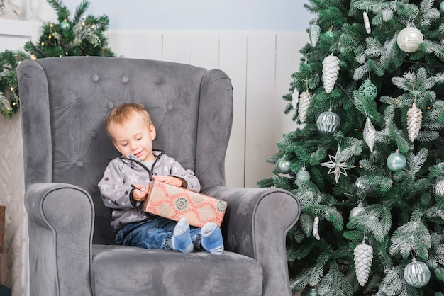 Niño en sofá con regalo