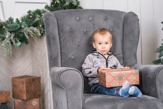 Niño en sofá con regalo