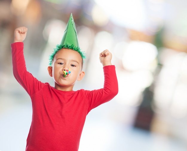 Niño con un sombrero de fiesta celebrando