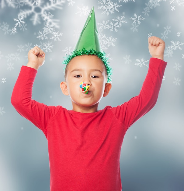 Niño con un sombrero de fiesta en con un fondo de nieve