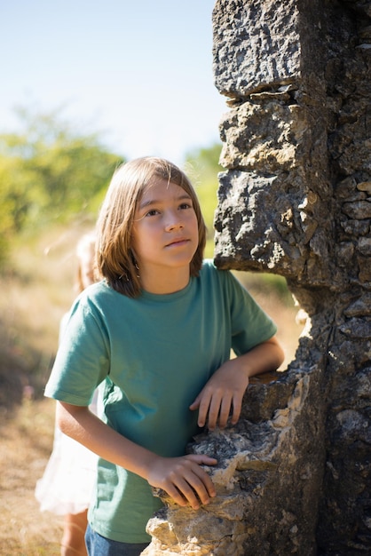 Foto gratuita niño soñador cerca de la muralla del castillo