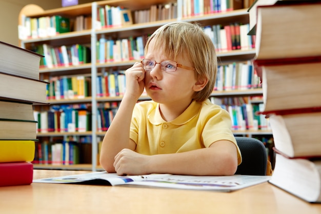 Foto gratuita niño soñando despierto en la biblioteca