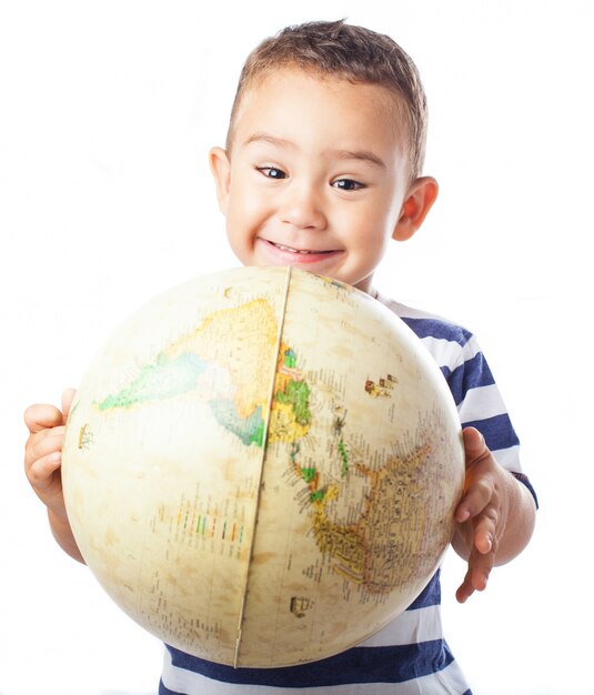 Niño sonriendo con un globo terráqueo