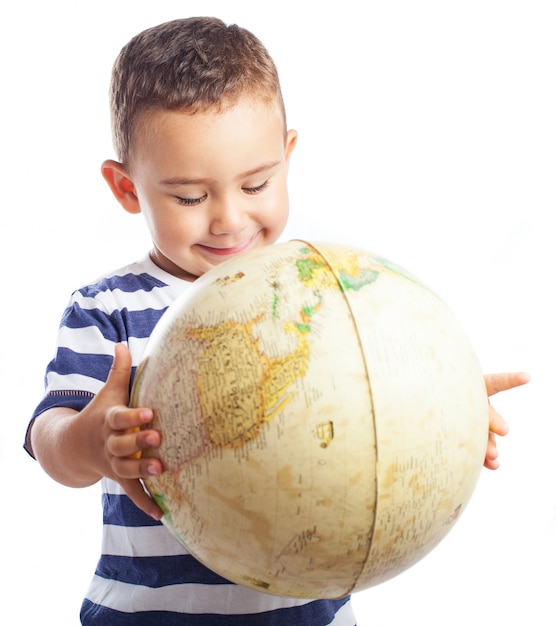 Foto gratuita niño sonriendo con un globo terráqueo