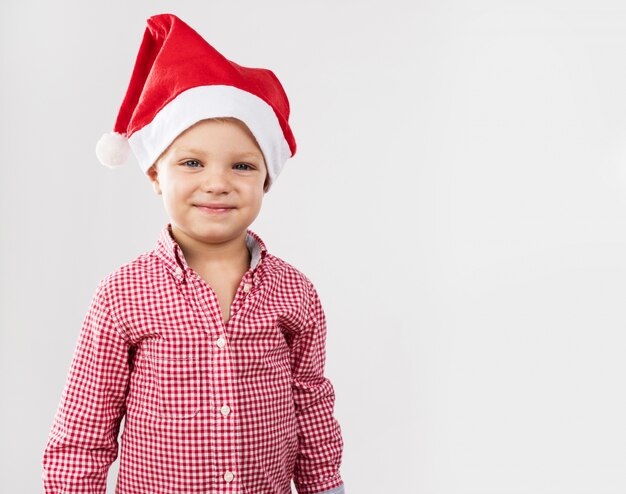 Niño sonriendo con gorro de papá noel