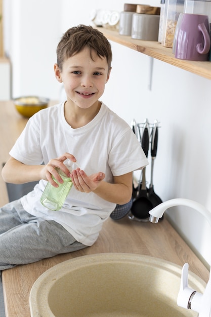 Foto gratuita niño sonriendo y lavándose las manos