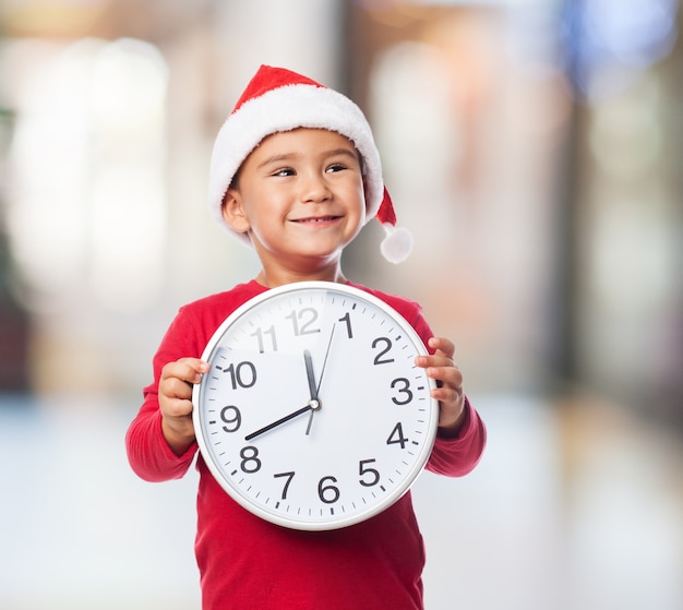 Niño sonriendo mientras sujeta un reloj