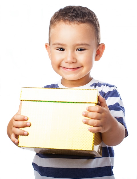 Foto gratuita niño sonriendo con un regalo dorado