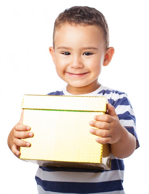 Niño sonriendo con un regalo dorado