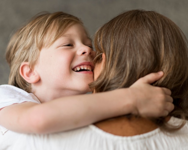 Niño sonriente abrazando a su abuela