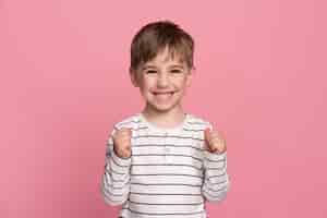 Foto gratuita niño sonriente aislado en rosa