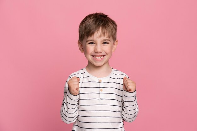 Niño sonriente aislado en rosa