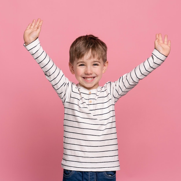 Niño sonriente aislado en rosa