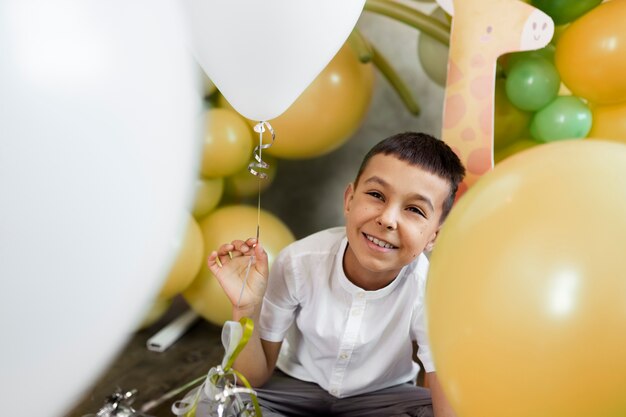 Niño sonriente de alto ángulo con globos