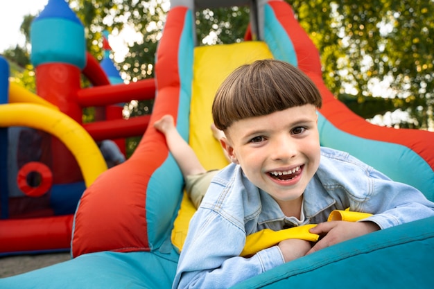 Niño sonriente de ángulo bajo en casa de rebote