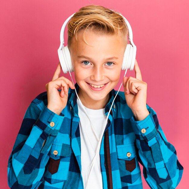 Niño sonriente con auriculares escuchando música